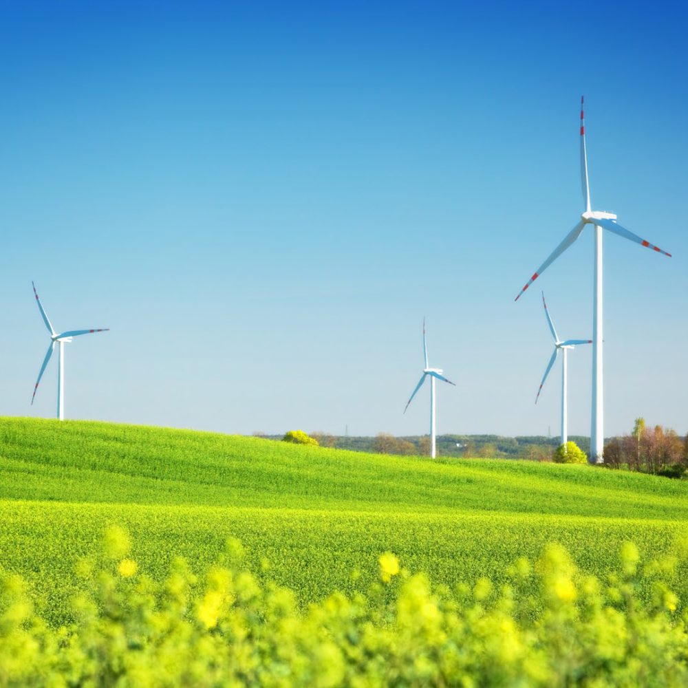 Wind turbines on spring field. Alternative, clean and natural source of energy is gaining pupularity. Eco farm.